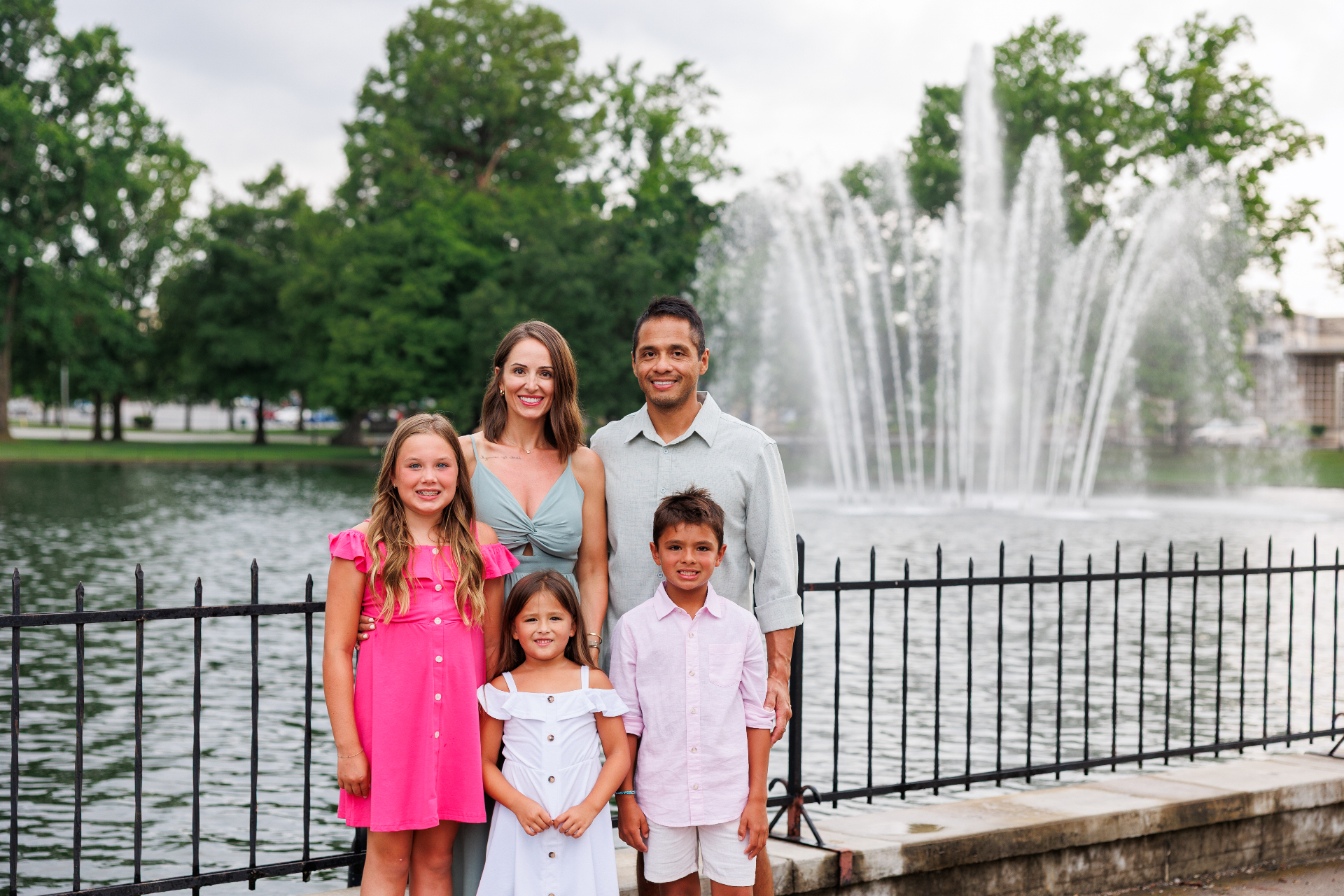 Dr. Traci Leon with her husband and three children by a lakeside fountain