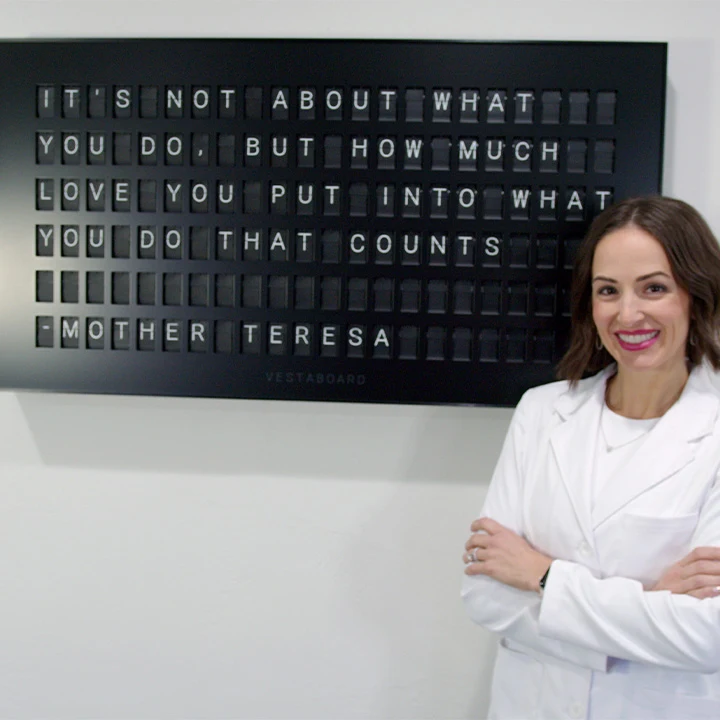 Dr. Traci Leon beside a quote display at Village Dental Studio
